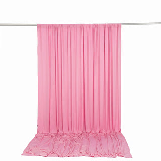 Pink satin backdrop curtain with draped floor panel on hanging rod