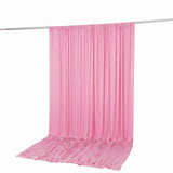 Pink satin drape curtain hanging on rod with floor pooling fabric
