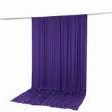 Purple draped backdrop curtain hanging from a rod on white background