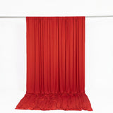 Red satin curtain draped on a rod against a white background