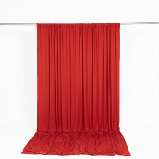 Red satin curtain draped on a rod against a white background