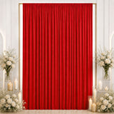 Red velvet event backdrop with white floral arrangements and candles