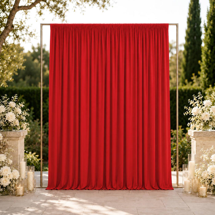 Elegant outdoor wedding backdrop with red curtain and white floral arrangements