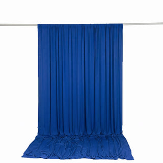 Blue draped fabric backdrop hanging on a silver rod, studio photography setup