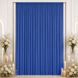 Blue event backdrop curtain with white floral candle decor on both sides