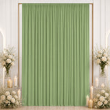 Elegant sage green curtain backdrop with white floral arrangements and candles