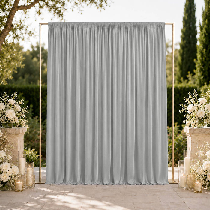Elegant outdoor wedding backdrop with gray draped curtain and floral decor
