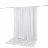 White curtain draped on a metal rod with fabric pooling on the floor