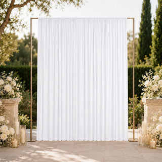 Elegant outdoor wedding backdrop with white drapery and floral arrangements