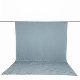 Light blue fabric backdrop draped over a studio crossbar and floor