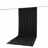 Black draped studio backdrop curtain on support rod, white background