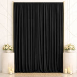 Elegant black wedding backdrop with gold frame, white flowers, and candles