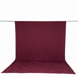 Burgundy fabric backdrop with matching floor drape on a studio rod