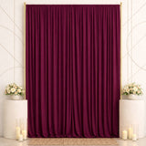 Elegant burgundy curtain backdrop with floral arrangements and candles