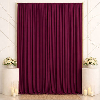 Elegant burgundy curtain backdrop with floral arrangements and candles