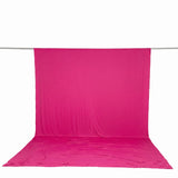 Bright pink fabric backdrop and floor drape on a studio rod