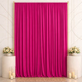 Pink satin backdrop with floral pedestals and candles for elegant event decor