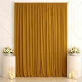 Elegant gold curtain backdrop with white floral arrangements and candles