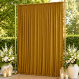 Gold wedding backdrop curtain with floral arrangements and lanterns outdoors