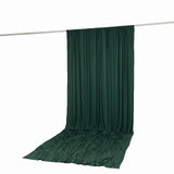 Dark green draped fabric backdrop on hanging rod, studio photo background
