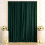 Elegant dark green curtain backdrop with white floral arrangements and candles