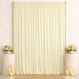 Elegant ivory curtain backdrop with gold frame, floral arrangements, and candles