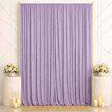 Lavender draped backdrop with floral pedestals and candles for elegant event decor