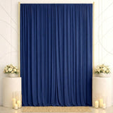 Elegant navy blue curtain backdrop with white floral arrangements and candles