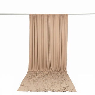 Beige draped fabric backdrop curtain on a studio rod, product display background