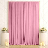 Pink wedding backdrop with gold frame, floral arrangements, and candles
