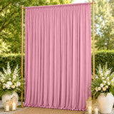 Pink draped wedding backdrop with gold stand and floral arrangements