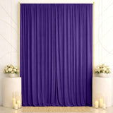 Elegant purple draped backdrop with floral accents and candles for events