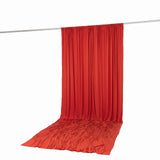 Red draped fabric curtain hanging on a rod, studio backdrop on white background