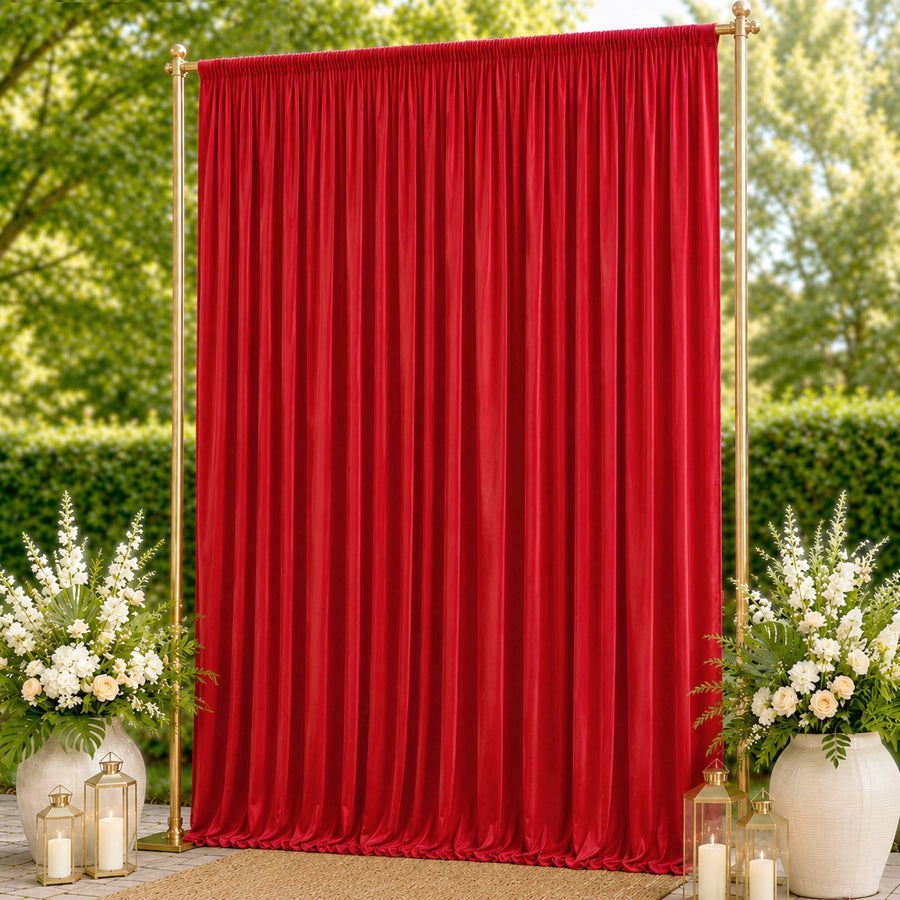 Red wedding backdrop curtain with gold frame, floral arrangements, and lanterns