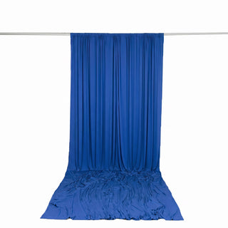 Blue draped backdrop curtain on hanging rod with floor train