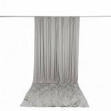 Light gray draped curtain hanging from a silver rod on a white background