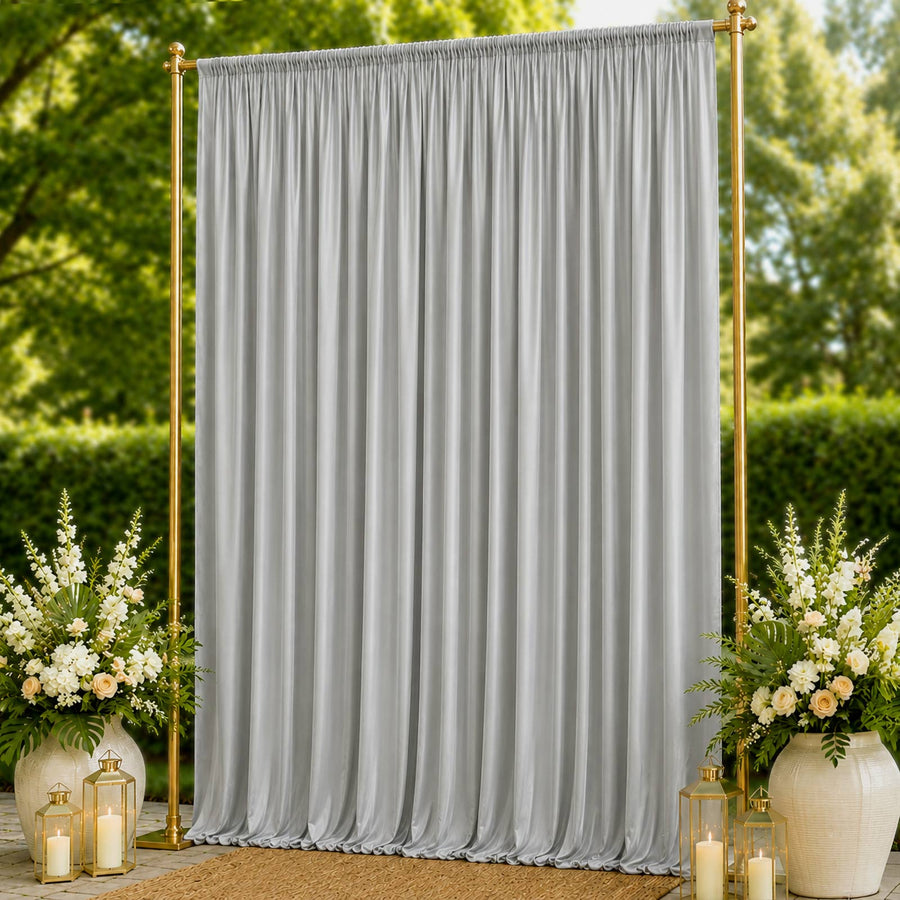 Elegant silver event backdrop curtain with gold frame and floral arrangements