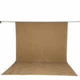 Tan photography backdrop cloth hanging on a support rod