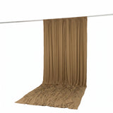 Beige sheer curtain panel draped on hanging rod, studio product display