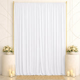 Elegant white wedding backdrop with gold frames, floral arrangements, and candles