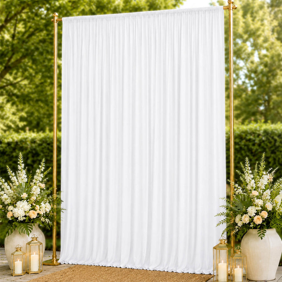 Gold frame white draped wedding backdrop with floral arrangements and lanterns