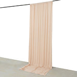 Beige sheer curtain draped on a black rod against a white wall