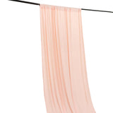 Sheer peach chiffon curtain panel hanging on a black rod