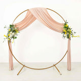 Round gold wedding arch with blush draping and floral arrangements