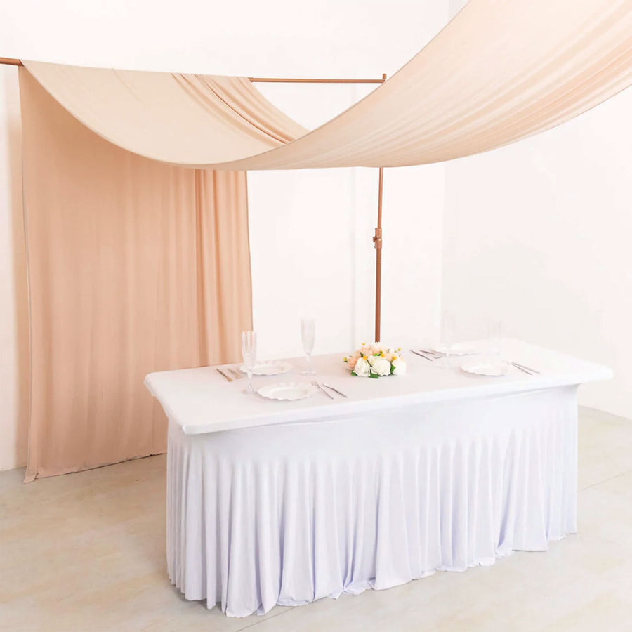 Elegant wedding table with beige drapery and floral centerpiece