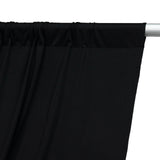 Black curtain fabric draped on a rod, showcasing smooth texture and color contrast.