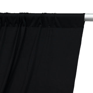 Black curtain fabric draped on a rod, showcasing smooth texture and color contrast.