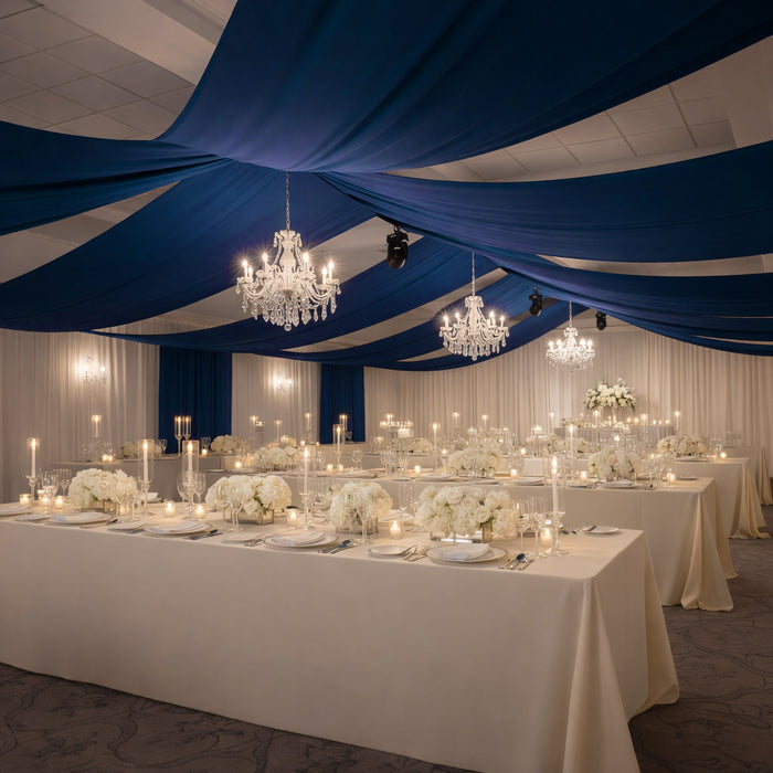 Elegant wedding reception setup with white flowers and chandeliers.