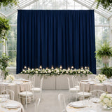 Elegant wedding reception setup with navy backdrop and floral decor.