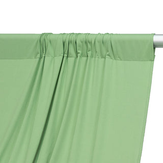 Green curtain fabric draped elegantly on a rod.